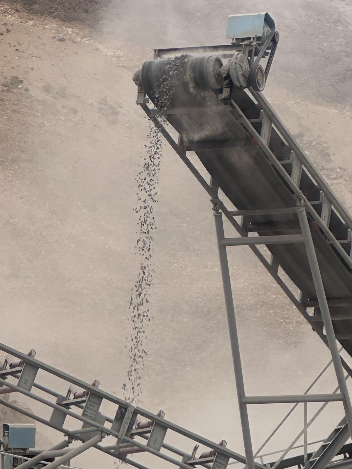 Crushed aggregate falling from a conveyor head